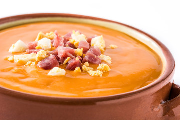 Typical Spanish salmorejo cream with ham and egg isolated on white background. Close up