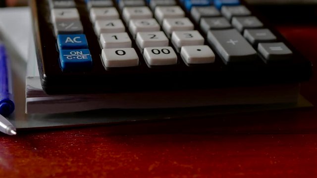 Ball pens , calculator on white papers pan shot, camera movement from left to right.