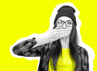 Excited surprised young woman covers hands open mouth over yellow background. Emotional female portrait. Hipster girl.