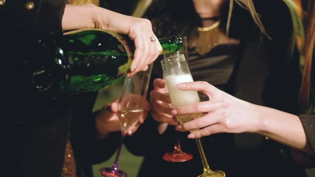 Girls party. Fun outdoor celebration. Female friends drinking champagne on the street with night city lights.