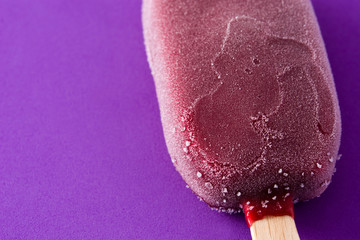 Strawberry popsicle on violet background. Close up. Copyspace
