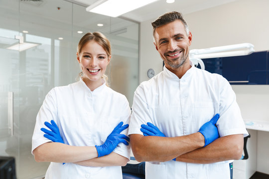 Image of handsome happy man doctor and young woman assistant working in medical dentist center