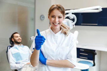 Abwaschbare Fototapete Zahnärzte Glückliche junge Ärztin im medizinischen Zahnarztzentrum.