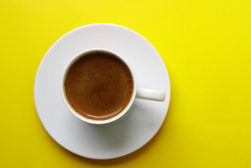 Cup of Turkish coffee on yellow color background