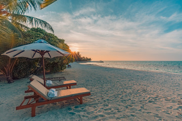 Obraz na płótnie Canvas Beautiful beach sunset, loungers and umbrella. Tropical landscape, calmness and inspiration concept