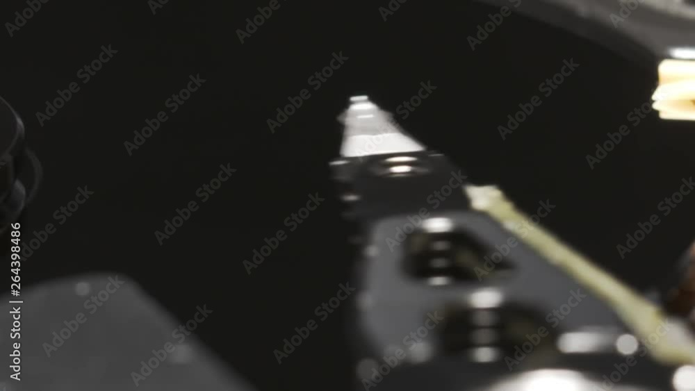 Poster operating head of computer hard disk drive. slow motion macro shot