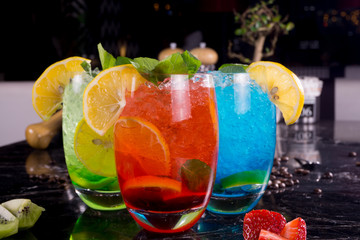 Three glasses of juicy cocktails on black background