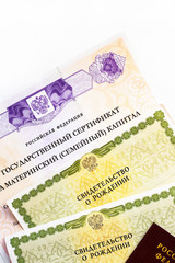 Moscow, Russia - April, 2019: Text Russian Federation State certificate on maternity family capital, passport, certificate of birth. State support for family at birth of second child. White background