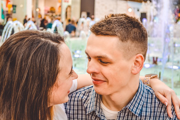 The loving young couple to have fun in shopping center near the fountain. Positive emotions. Happiness of newlyweds.