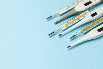 Medical thermometers glass and electronic on blue background. Copy space for text.