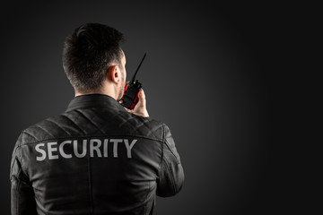 The man, security, is holding a walkie-talkie. The concept of protection, protection of...