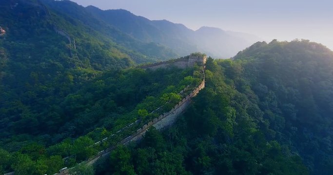Drone shot of Great Wall of China in Mutianyu (China) at sundown in autumn flying forward over inaccessible parts of the Wall