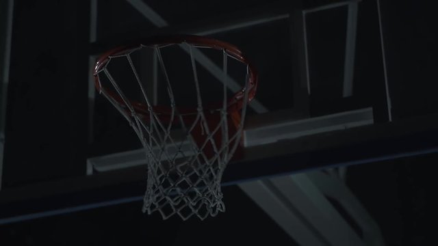 Basketball net close up. A man, player put a ball inside basketball hoop.
