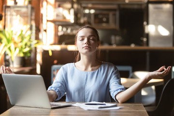 Young woman sitting at table in cafe relaxing do meditation