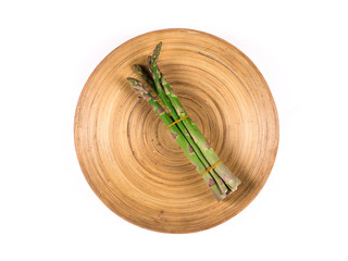 fresh asparagus bunch on a plate on a white background