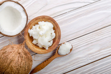 Flat lay background of coconut shell hard oil in wooden bowl on white wooden table