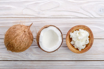 Flat lay background of coconut, coconut shell, hard oil in wooden bowl on white wooden table