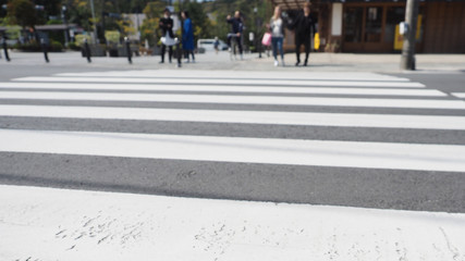 Fototapeta premium Blur crosswalk with tourists waiting at the opposite side.