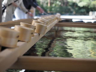 The wooden ladles at the clear water pond for cleaning hands infront of the shrine.
