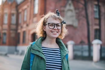 Fototapeta premium Portrait of a young woman on the background of a European sunny street.