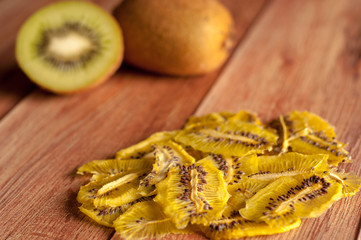 Healthy snack. Homemade dehydrated kiwi chips and fresh apples on a rustic wooden background
