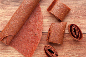 Homemade fruit leather of grape on a wooden background. Pastila. Fruit rolls. Fresh fruits