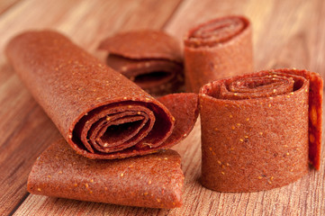 Homemade fruit leather of strawberry on a wooden background. Pastila. Fruit rolls. Fresh fruits