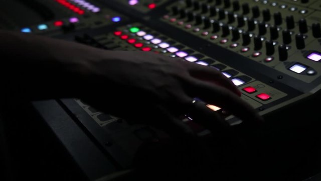 remote recordists closeup. Hand adjusts sound effects. Electric machine on table for working of sound designer or club dj at party in nightclub. 