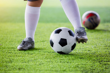 kid soccer player jogging with control ball to shoot to goal on artificial turf.
