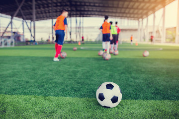 Obraz na płótnie Canvas football on green artificial turf with blurry soccer team training