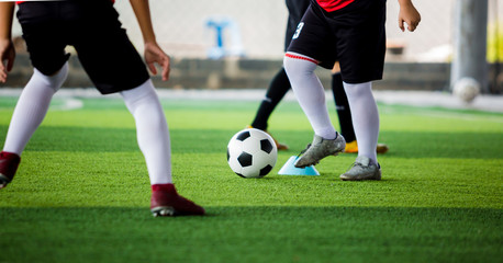 kid soccer player put white sport shoes jogging and control ball go to other players