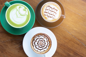 Coffee cup with Green Matcha latte art foam on wood table in coffee shop with copy space.Coffee is one of the most popular beverages.Improve Energy Levels and Burn Fat
