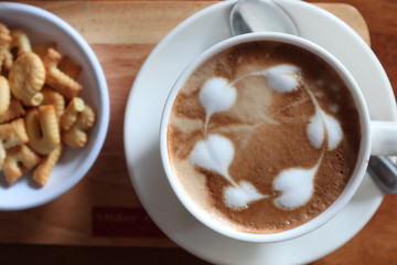 Coffee cup with latte art foam on wood table in coffee shop with copy space.Coffee is one of the most popular beverages.Improve Energy Levels and Burn Fat