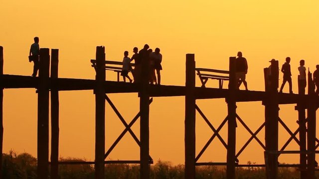 Silhouetted people on U Bein Bridge at sunset, Amarapura, Mandalay region, Myanmar, Lockdown.