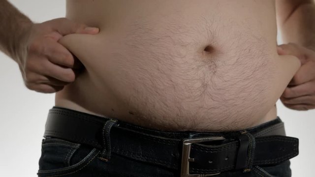 Close-up of a large male belly. The fat man touches his belly and sides.