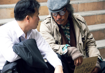 Close-up Business man sadness and homeless man on walking street.