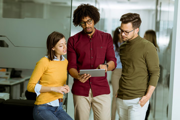 Multiethnic business team using a digital tablet in the office of small startup company
