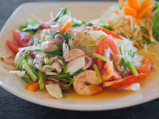 Traditional Thai cuisine. Rice noodle salad, fresh vegetables and herbs and seafood on a plate in a cafe. Authentic fresh traditional thai food at the restaurant