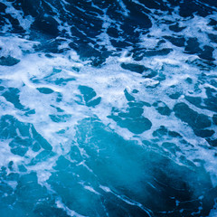 Ocean wave water sea of rippled water with white wave bubbles near the big boat on summer holiday.