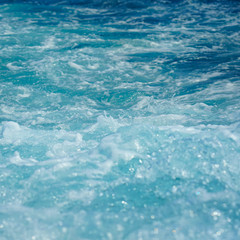 Ocean wave water sea of rippled water with white wave bubbles near the big boat on summer holiday.