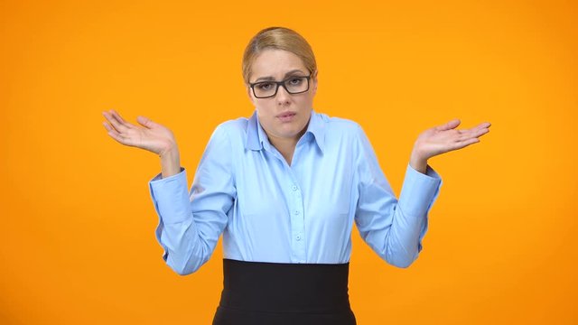 Confused business lady throwing up hands, having no idea, lack of inspiration