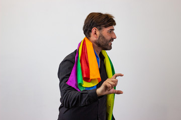 Portrait of handsome young man with gay pride movement LGBT Rainbow flag and brown hair holding up...