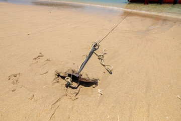 Small Anchor in Beach Sand for Parking Tourism Boat in the Island