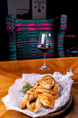 Grilled chicken and glass of red wine of the interior in the restaurant.