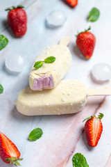 Strawberry ice creams on sticks covered with white chocolate
