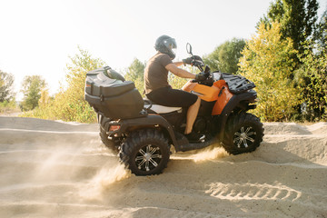 Atv riding in sand quarry, dust clouds, quad bike