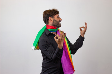 Portrait of handsome young man with gay pride movement LGBT Rainbow flag and brown hair and a...