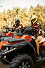 Fototapeta na wymiar Two atv riders before the trip in summer forest