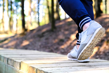 Jogging in sneakers on the bridge in the Park. Sport, Health and physical culture concept.
