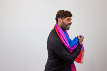 Portrait of handsome young man with gay pride movement LGBT Rainbow flag and brown hair looking...